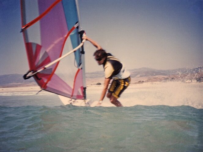 Planche à voile en action, voile rose et bleue, années 80