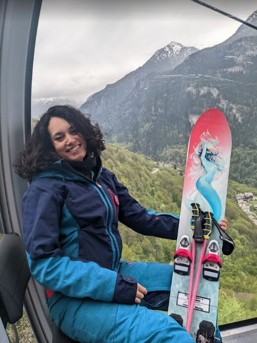 Sahar Sboui assise en télécabine, son monoski à la main, montagnes en arrière-plan