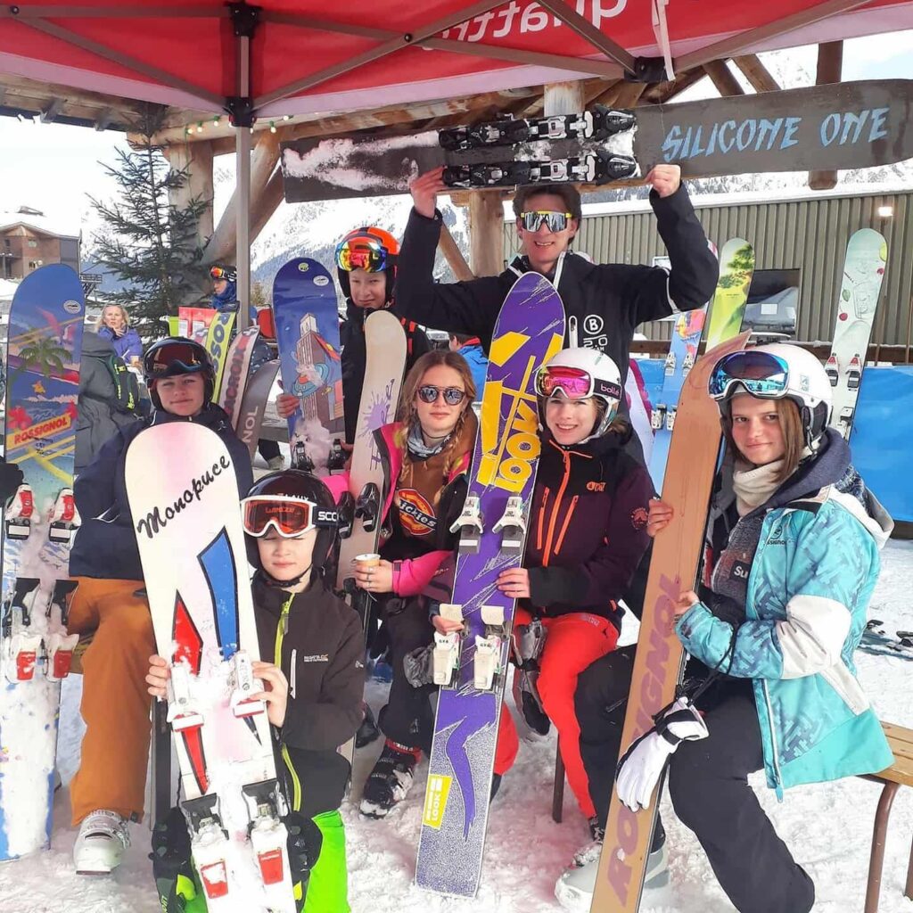Groupe de participants sous le barnum Silicone One, monoskis brandis à bout de bras