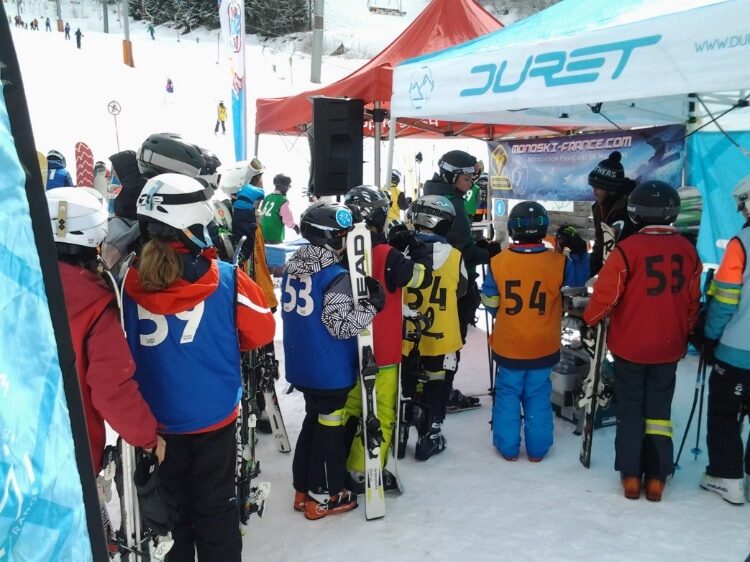 Enfants en dossards numérotés attendant leur passage devant le stand Duret