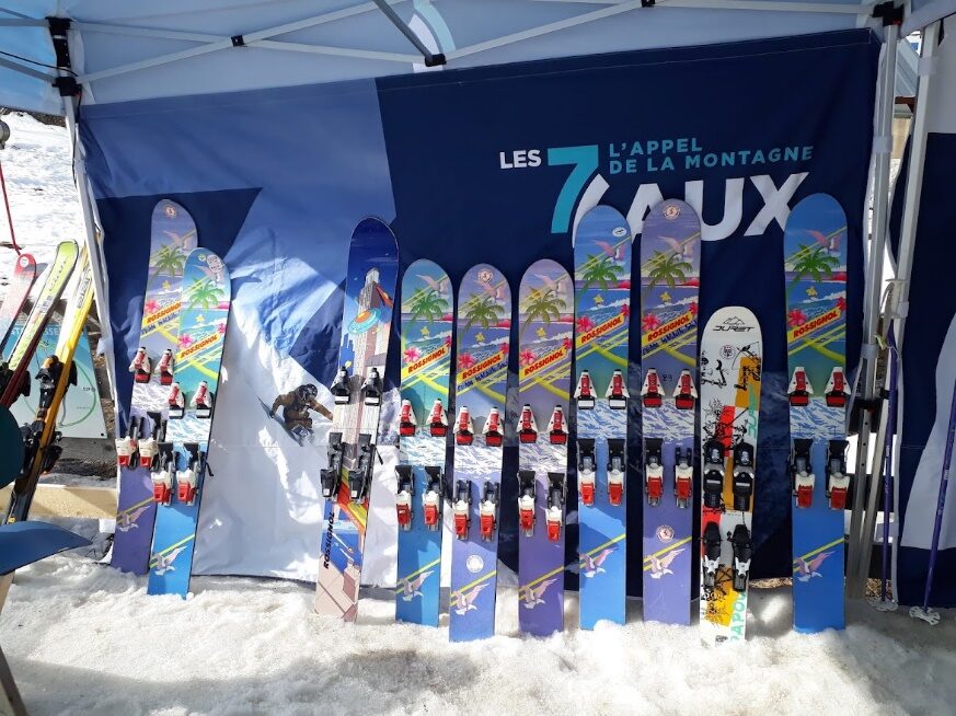 Alignement de monoskis colorés devant la banderole des 7 Laux