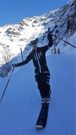 Rider en monoski vu de dos, en pleine descente sur une pente bleutée