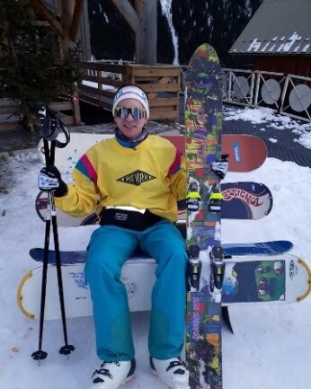 Rider en tenue jaune et bleue des années 80, assis devant un alignement de planches
