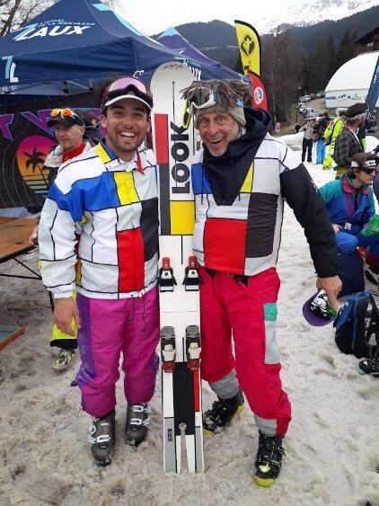 Deux riders brandissant leurs skis Look, en tenues rouges et blanches