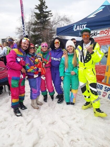 Riders en combinaisons fluo réunis devant le stand du club sportif des 7 Laux