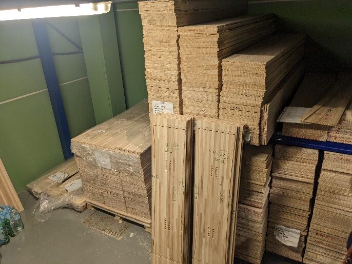 Planches de bois lamellé empilées dans l'atelier, matière première des monoskis