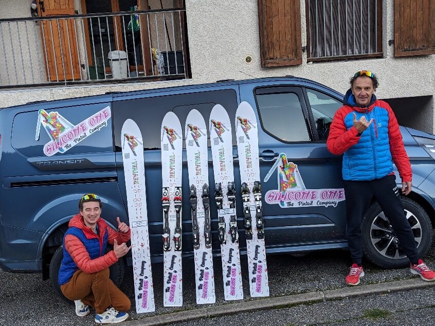 Deux membres de Silicone One présentant quatre monoskis de présérie devant la Team-Car