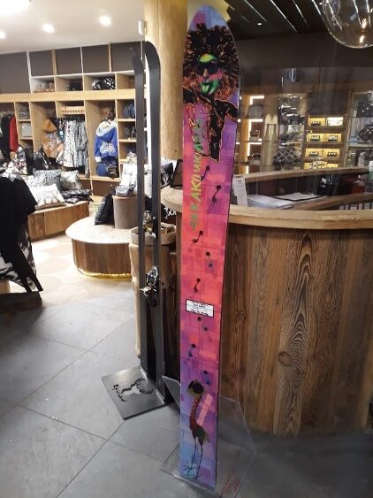 Monoski aux décors roses et bleus dressé dans une vitrine de magasin de sport